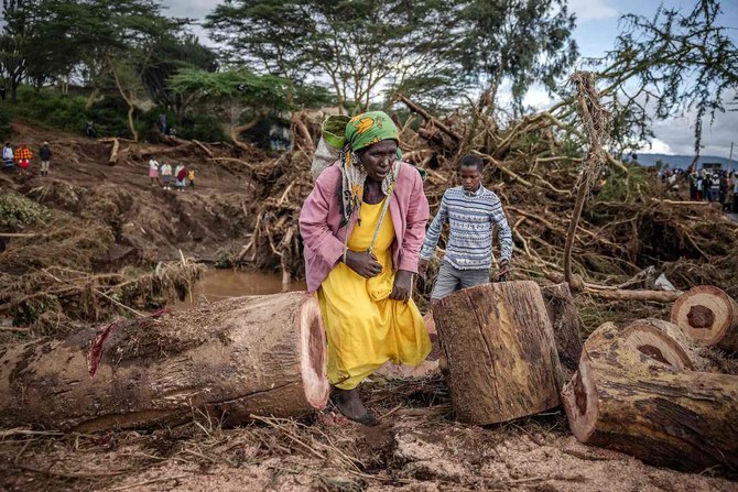 A woman walks in an area full of damaged trees following flash floods and landslides in Mai Mahiu. 